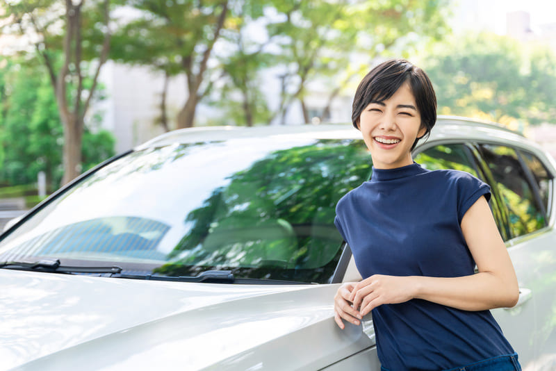 車に寄りかかる女性